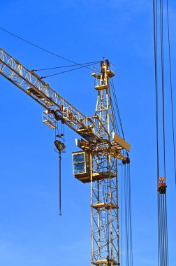 Mavi gökyüzüne karşı yüksek inşaat kulesi vinci