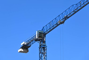 Mavi gökyüzüne karşı yüksek inşaat kulesi vinci