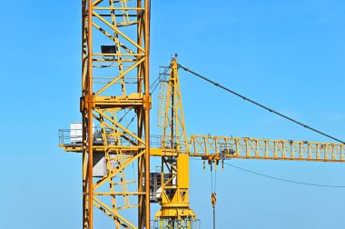 Mavi gökyüzüne karşı yüksek inşaat kulesi vinci