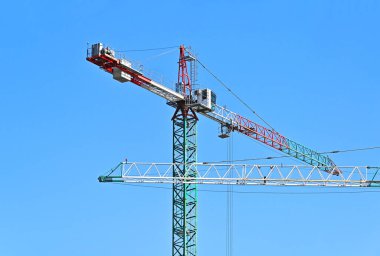 Mavi gökyüzüne karşı yüksek inşaat kulesi vinci