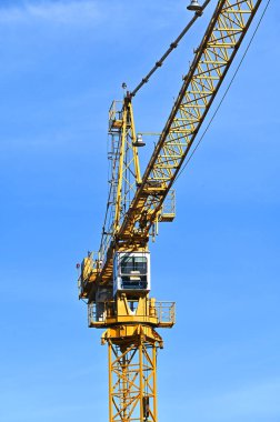 Mavi gökyüzüne karşı yüksek inşaat kulesi vinci