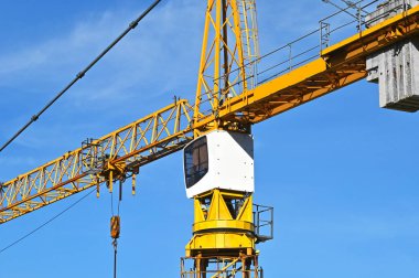 Mavi gökyüzüne karşı yüksek inşaat kulesi vinci