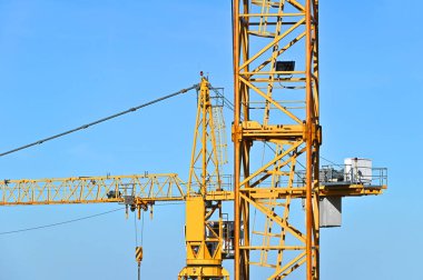 Mavi gökyüzüne karşı yüksek inşaat kulesi vinci