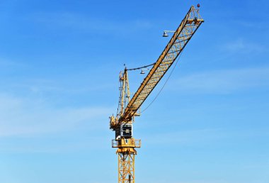 Mavi gökyüzüne karşı yüksek inşaat kulesi vinci