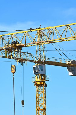 Mavi gökyüzüne karşı yüksek inşaat kulesi vinci