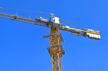 Mavi gökyüzüne karşı yüksek inşaat kulesi vinci