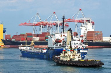 Tugboat assisting bulk cargo ship clipart