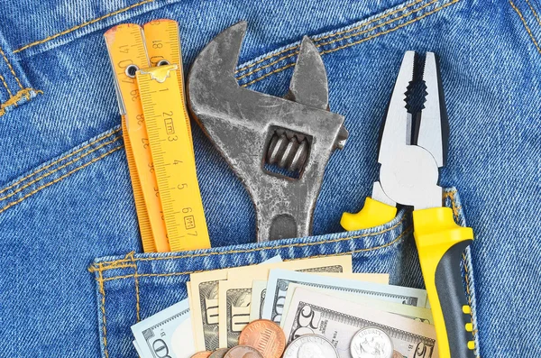 Деньги и инструмент в джинсовом кармане — стоковое фото