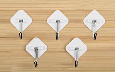 Bambu ahşap arka planda beyaz yapışkan kancalar.