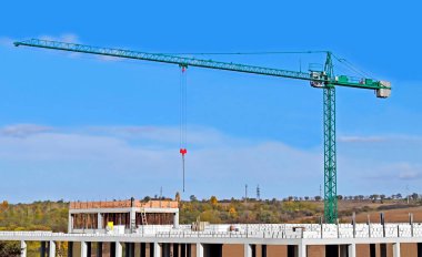 Mavi gökyüzüne karşı kule vinci ve inşaat