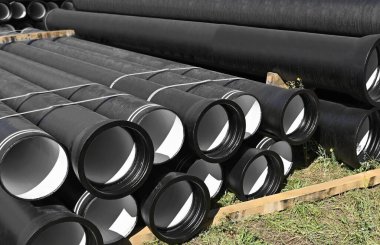 İnşaat alanına istiflenmiş güçlendirilmiş beton kanalizasyon boruları.