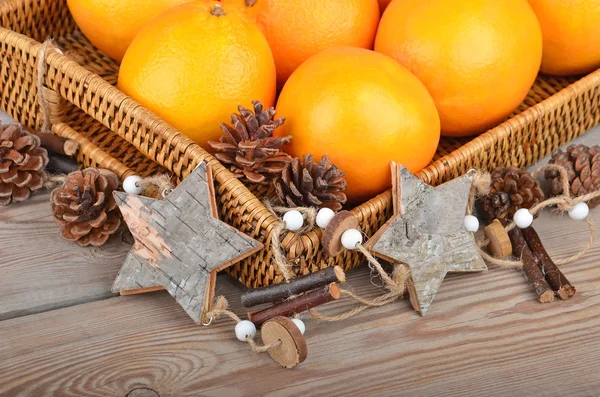 Orange in wickered tray with Christmas decor — Stock Photo, Image