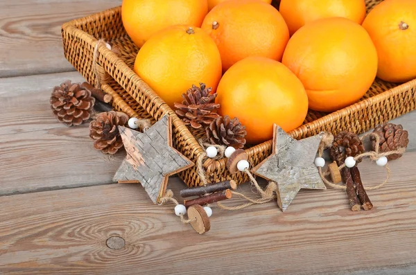 Orange in wickered tray with Christmas decor — Stock Photo, Image