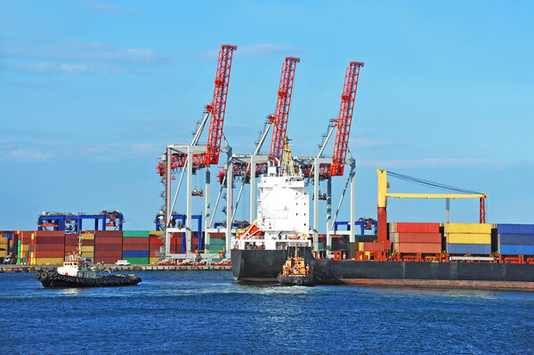 Буксир, помогающий грузовому контейнеру
