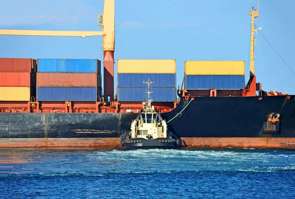 Tugboat assisting container cargo ship — Stock Photo, Image