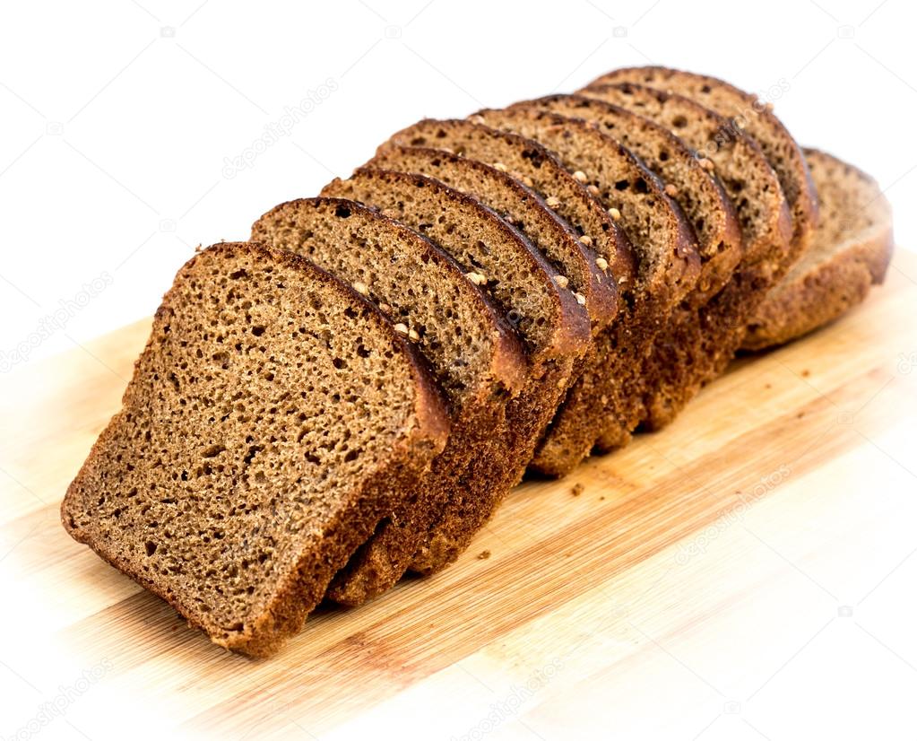 Cut slices of rye bread with caraway seeds on a wooden board