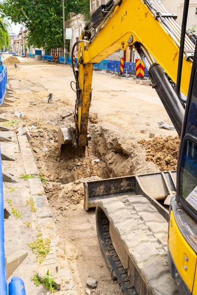 Sarı kazıcı yola hendek kazıyor.