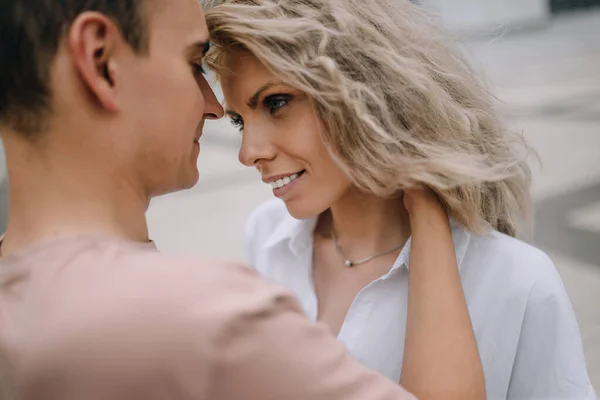 Güzel genç çift yüz yüze oturuyor ve gülümsüyor. 