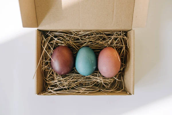 Kutudaki saman üzerinde renkli yumurtalar.