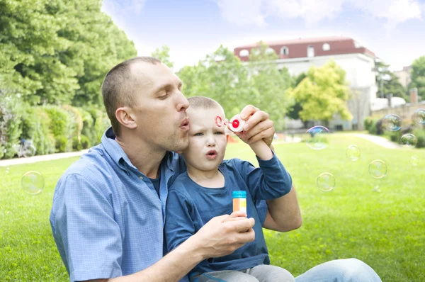 Dad and son blowing soap bubbles — Stock Photo, Image