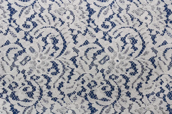 Tissu en dentelle blanche avec motif floral sur bleu — Photo