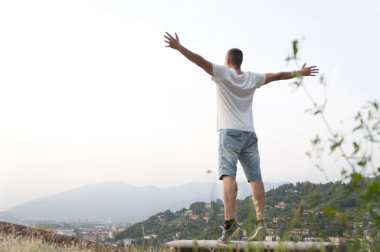 adam silah şehir manzarasının yanında uzanmış