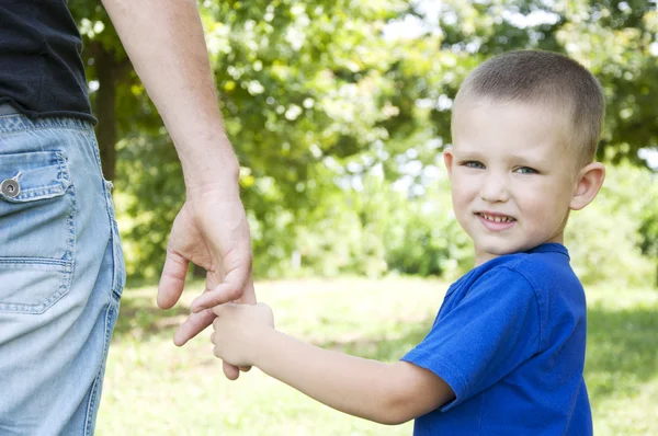 Vader en zoon hand in hand wandelen in het park — Stockfoto