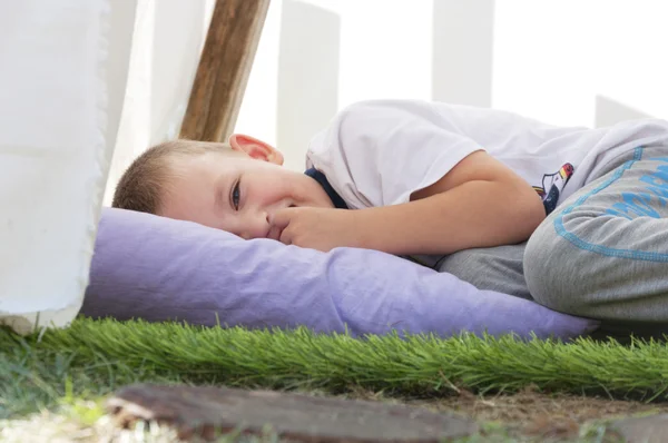 Kleine jongen liggend op een kussen — Stockfoto