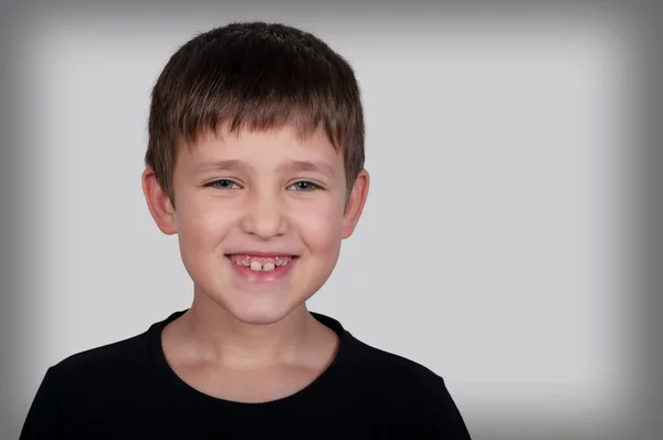 Portret Van Een Lachende Jongen Een Grijze Achtergrond — Stockfoto