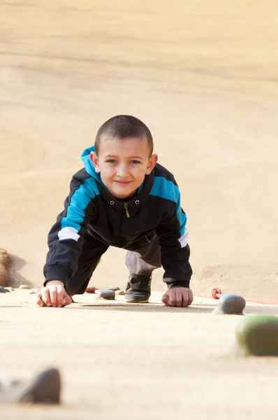 Boy climbing up the cliff — Stock Photo, Image