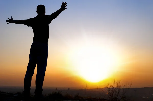 Man arms outstretched to the side at sunset — Stock Photo, Image