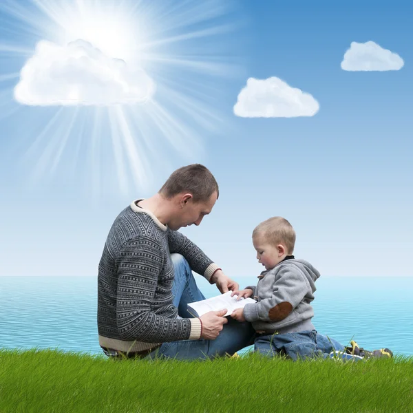 Dad and son reading a book on nature — Stock Photo, Image