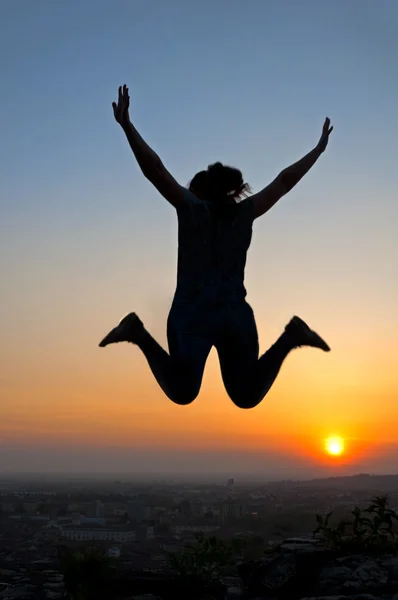 Kadın siluet günbatımında atlama — Stok fotoğraf