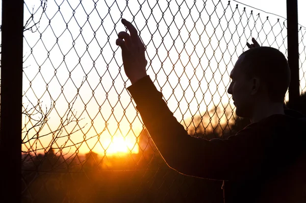 Silhouette di un uomo dietro la recinzione — Foto Stock