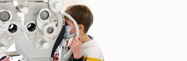 在现代诊所 验光师用特殊的眼科设备检查病人的儿子 儿童视力矫正 — 图库照片