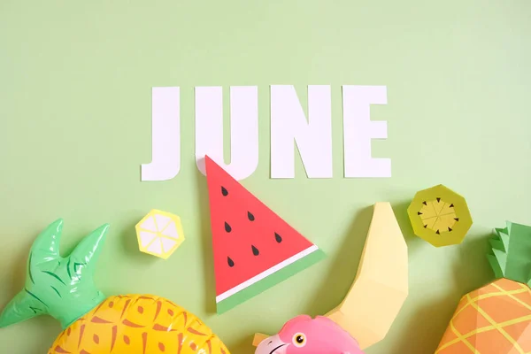 Hello, june. Exotic fruits made of paper with inflatable elements on green background. Summer concept. Holiday