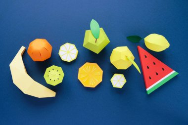 Klasik mavi arka planda kağıttan yapılmış egzotik meyveler. Vitamin kavramı