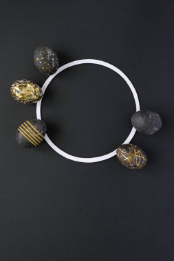 Yuvarlak çerçeveli, siyah arka planda altın desenli siyah paskalya yumurtaları. Lüks Paskalya