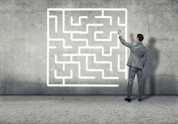 Businessman drawing labyrinth on wall — Stock Photo, Image