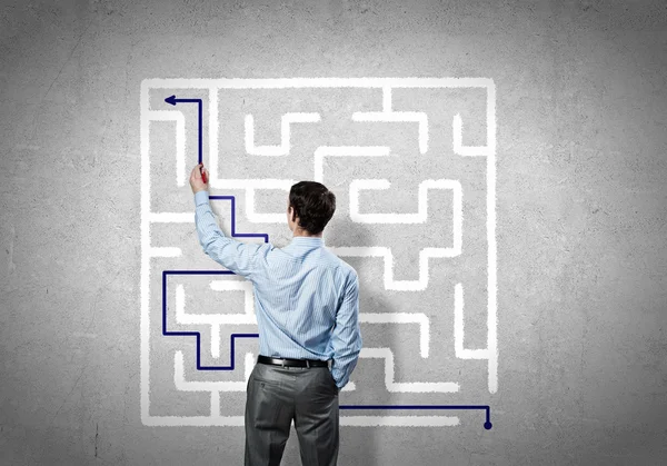 Businessman drawing labyrinth on wall — Stock Photo, Image