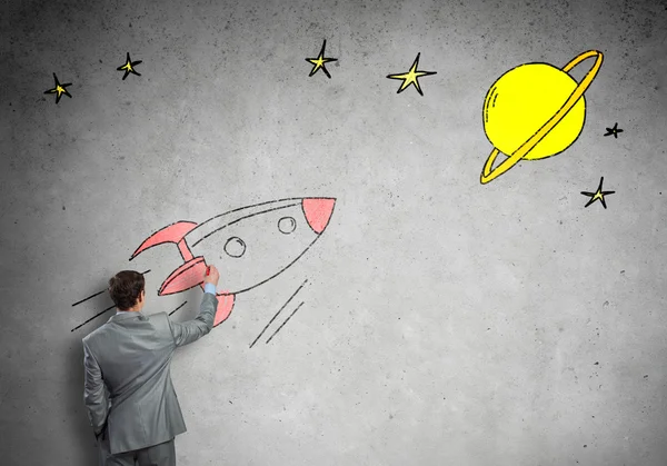 Businessman drawing rocket on wall — Stock Photo, Image