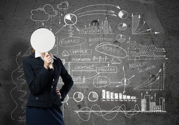 Businesswoman hiding her face behind paper — Stock Photo, Image