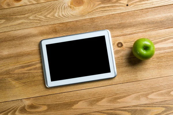 Tablet and apple on table