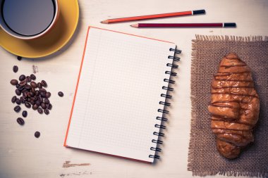 Not defteri ve kruvasan ile kahve