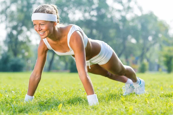 Kadının yapması Push ups parkta — Stok fotoğraf