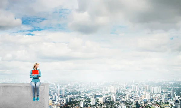 Binanın tepesinde oturan kadın — Stok fotoğraf