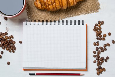 Not defteri ve kruvasan ile kahve