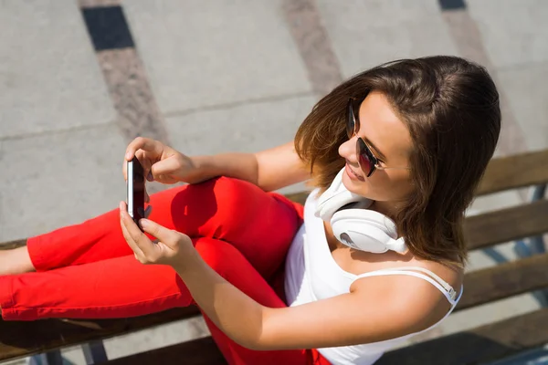 Женщина сидит с мобильным телефоном — стоковое фото