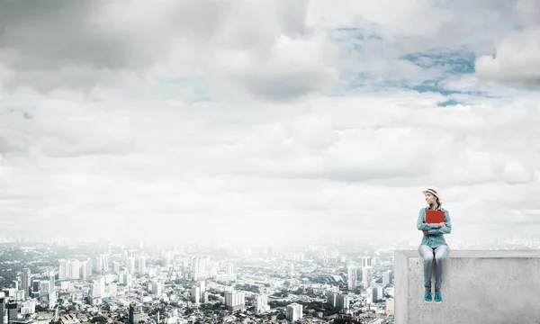 Mujer sentada encima del edificio — Foto de Stock