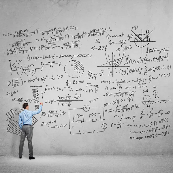 Homme dessinant des formules scientifiques — Photo